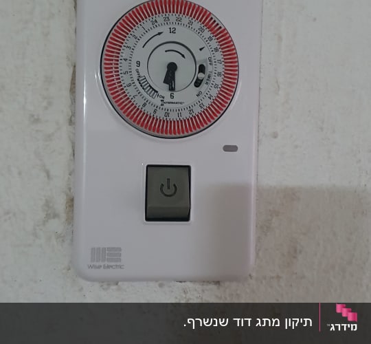 טיימר חשמלי עם כפתור הפעלה על קיר